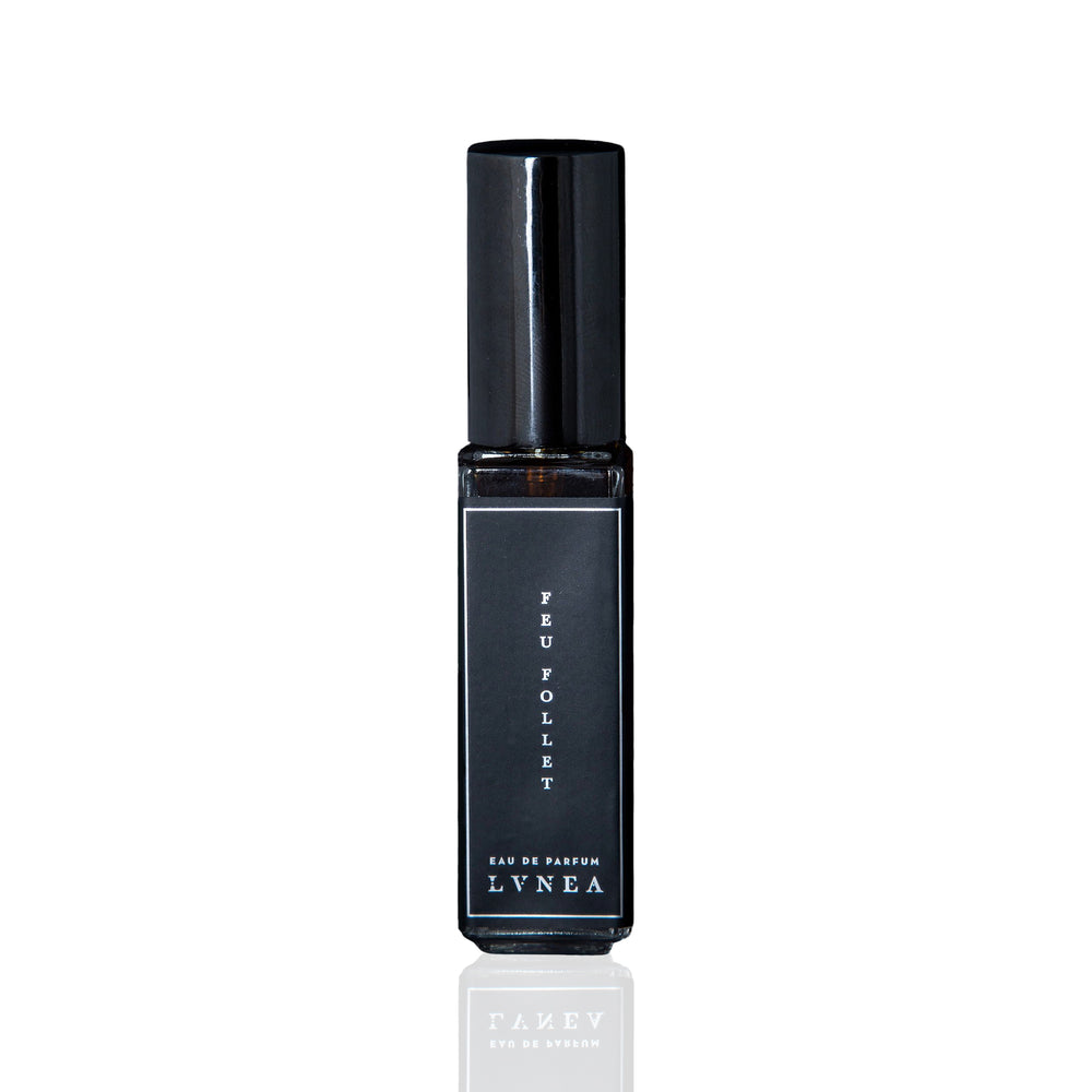 LVNEA Feu Follet Eau De Parfum - a black glass bottle containing a smoky, resinous fragrance with notes of pine tar, burnt wood, leather, and tree resin. Presented with an atomizer spray top. 30ml