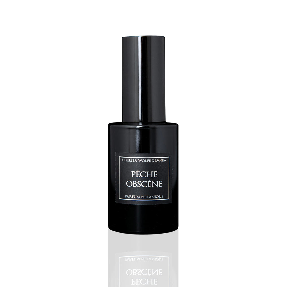 Amethyst glass bottle of LVNEA Pêche Obscène Eau de Parfum, featuring notes of peach, jasmine, and patchouli, encased in a matte black tube.