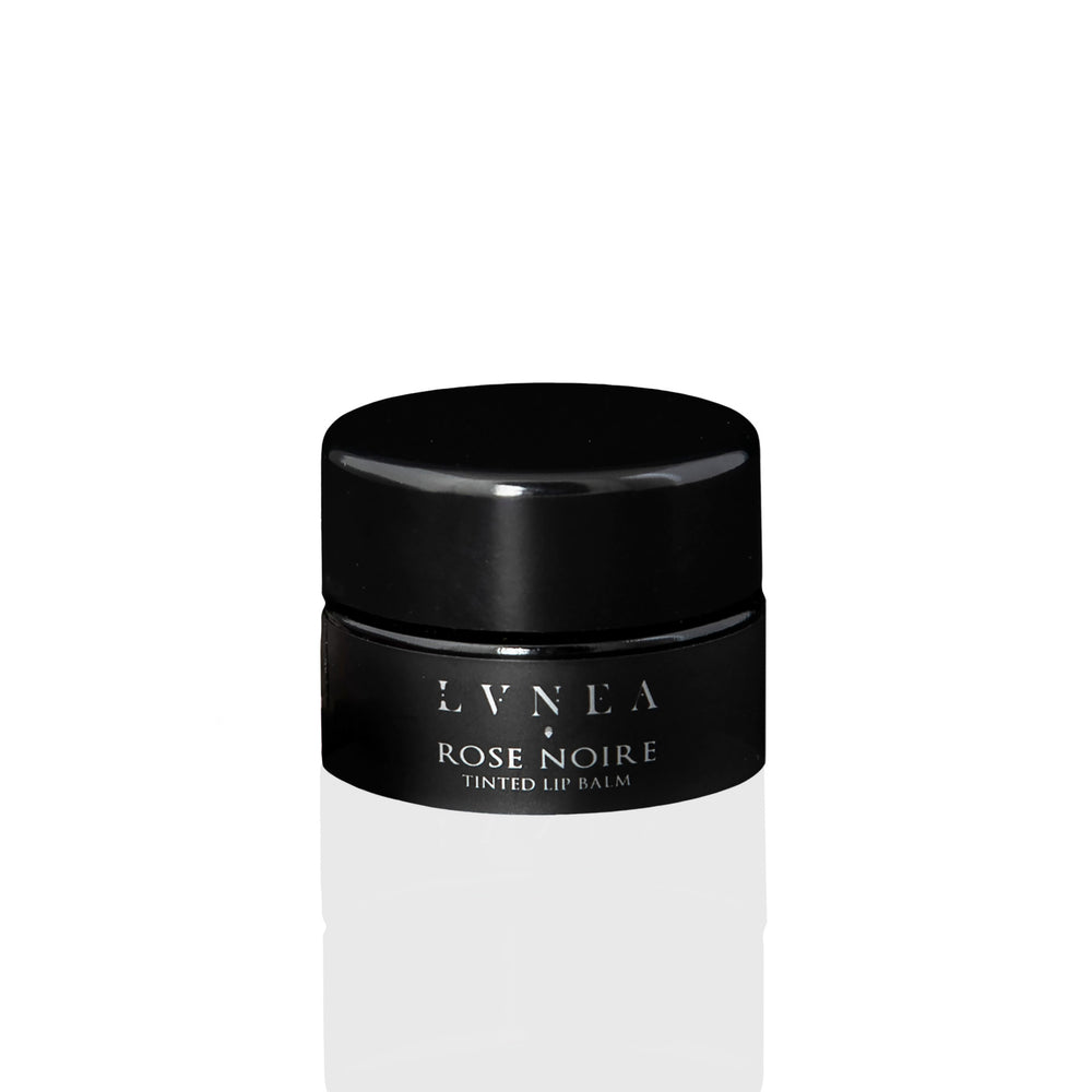 Luxurious Tinted Lip Balm: A rich, nourishing lip balm with a dark dusty rose tint, featuring botanical oils, butters, and natural rose wax. Offers a light floral fragrance and sweet taste, perfect for enhancing lips or as a dewy cheek stain.