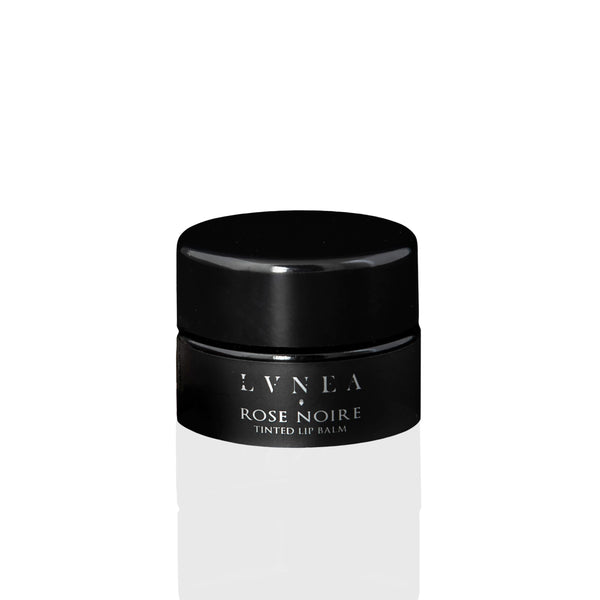 Luxurious Tinted Lip Balm: A rich, nourishing lip balm with a dark dusty rose tint, featuring botanical oils, butters, and natural rose wax. Offers a light floral fragrance and sweet taste, perfect for enhancing lips or as a dewy cheek stain.