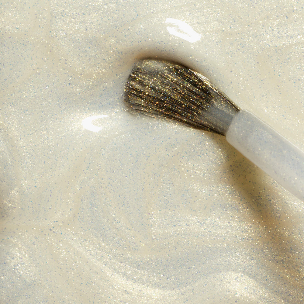 MANUCURIST Green Nail Polish Solar in a sheer white shade with golden shimmer, vegan, 12-free, and made in France.