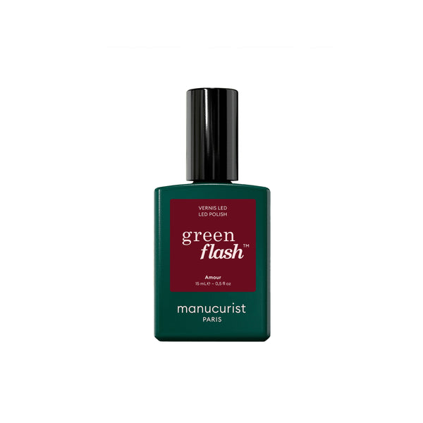 A bottle of Manucurist Green Flash LED gel polish with a dark green bottle, a black cap, and a dark red label on a plain white background.
