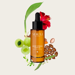Mauli Rituals hair oil bottle with botanical elements on a light background
