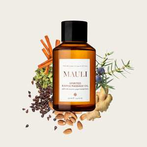 MAULI RITUALS Spirited Kapha Body Oil bottle surrounded by herbs and spices on a light background