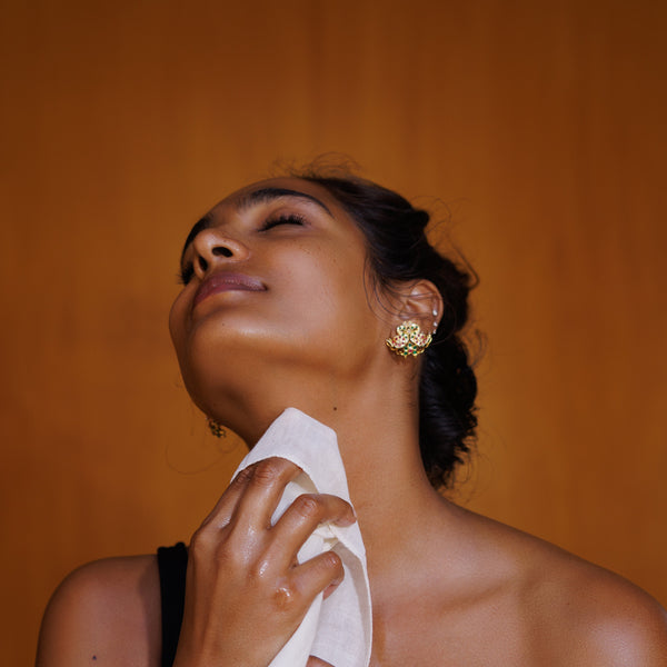 Woman with a gold earring against an orange background