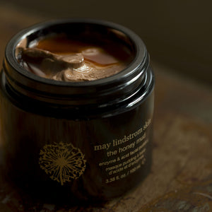 Jar of 'The Honey Mud' by May Lindstrom on a wooden surface