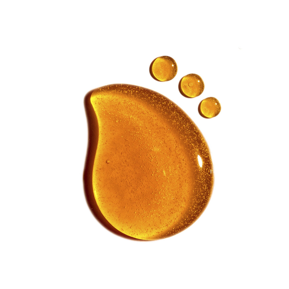 Black serum bottle with gold logo and dropper on a white background