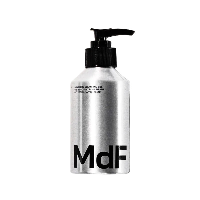 Silver bottle with black pump and 'MDF' branding on a white background