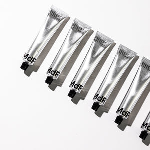 Multiple silver tubes with 'MDF' branding on a white background