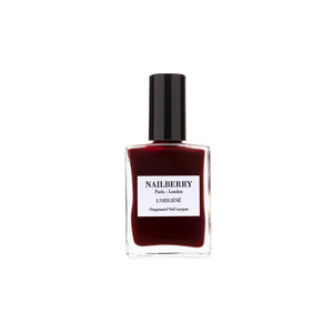 Bottle of Nailberry Kirsch Kiss dark cherry burgundy nail polish on white background.