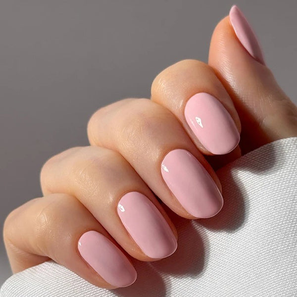 Hand with pink nail polish on a neutral background. NAILBERRY Kyoto Bloom