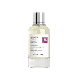 A clear glass bottle of Olfactory X Bergamot + Blossom Eau de Parfum with a silver cap and a white label featuring a purple 'Bb' logo, set against a plain white background.