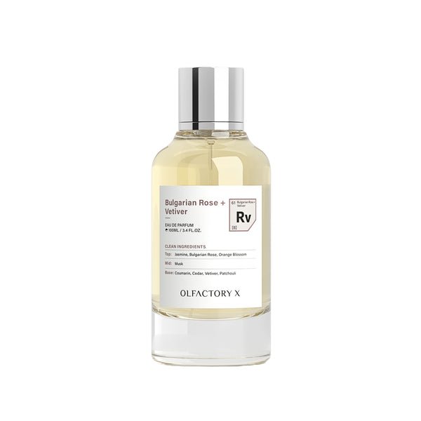 A clear glass bottle of Olfactory X Bulgarian Rose + Velliver Eau de Parfum with a silver cap, containing a pale yellow liquid, set against a plain white background.