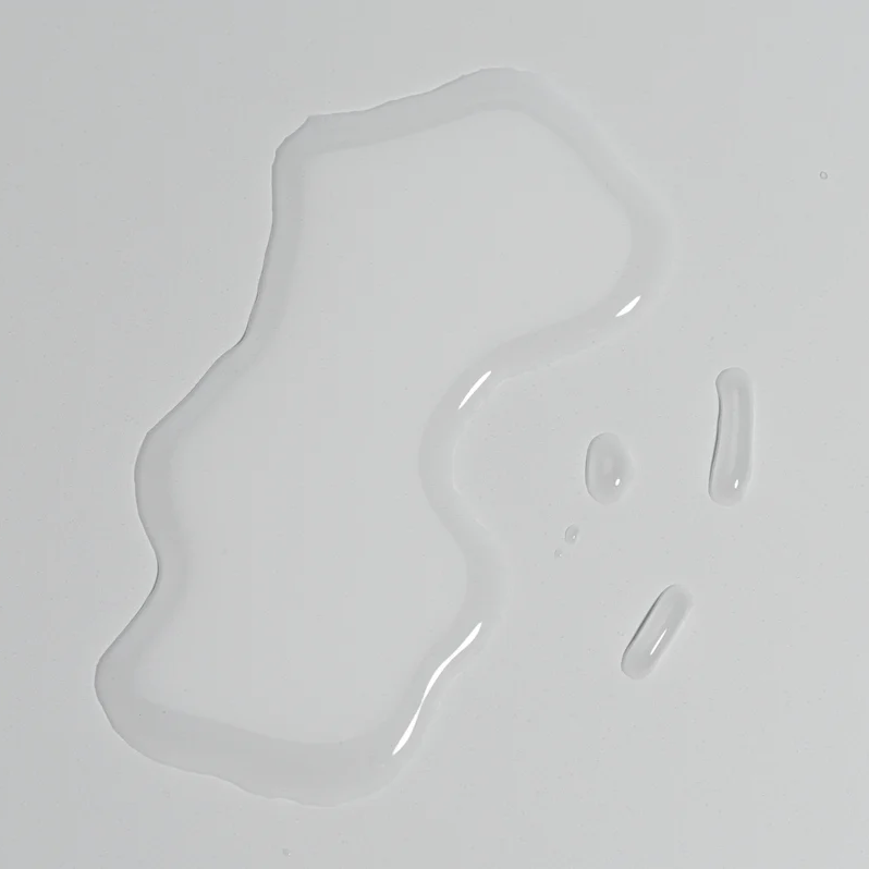 Clear bottle of Om skincare tonic with black cap on a white background