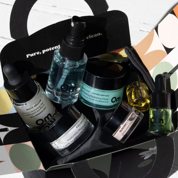 Collection of skincare products in a black box with 'Om Organics' branding.