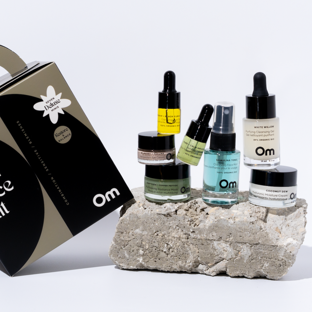 Collection of skincare products on a stone block with 'Om' branding. These are from OM ORGANICS Mini Face Care Kit for Combination Sensitive / Blemish Prone