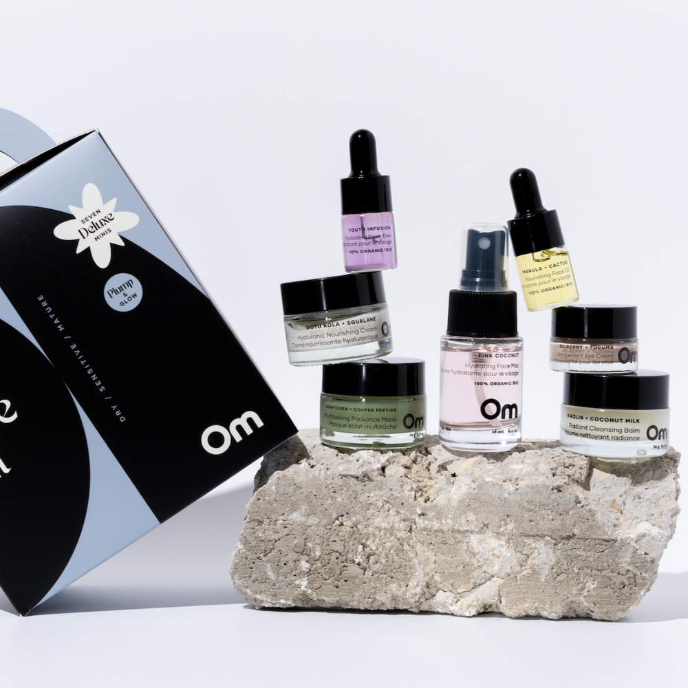 Skincare products on a stone block with Om brand packaging in the background- These are from OM ORGANICS Mini Face Care Kit for Dry / Sensitive / Mature skin