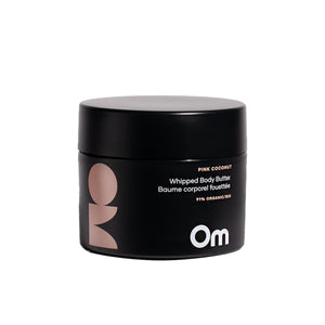 Om Organics Pink Coconut Whipped Body Butter in a glass jar, a rich and creamy moisturizer with a soft coconut and rose scent.