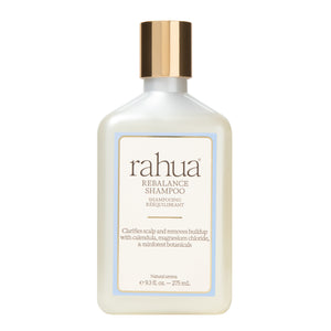 A bottle of Rahua Rebalance Shampoo with a white body, a metallic gold cap, and a cream-colored label with a light blue border, set against a plain white background.