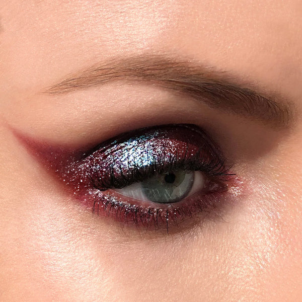 Close-up of a woman's eye with dramatic makeup. RITUEL DE FILLE Celestial Sphere Gelée Eye Gloss Cygnus