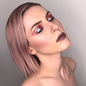 Woman with pink hair and dramatic makeup against a neutral background. RITUEL DE FILLE Celestial Sphere Gelée Eye Gloss Cygnus