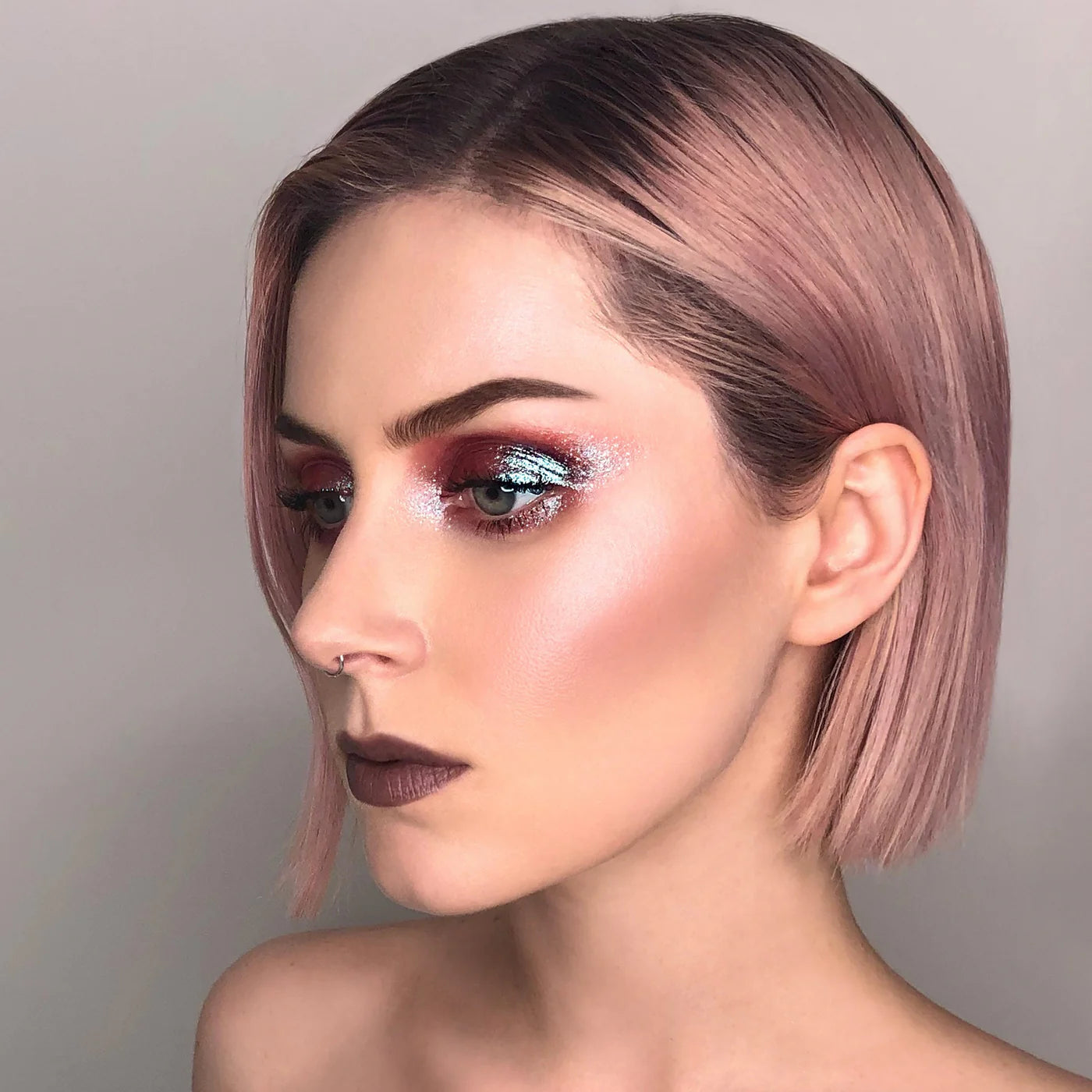 Woman with pink hair and glittery makeup against a neutral background. RITUEL DE FILLE Celestial Sphere Gelée Eye Gloss Cygnus