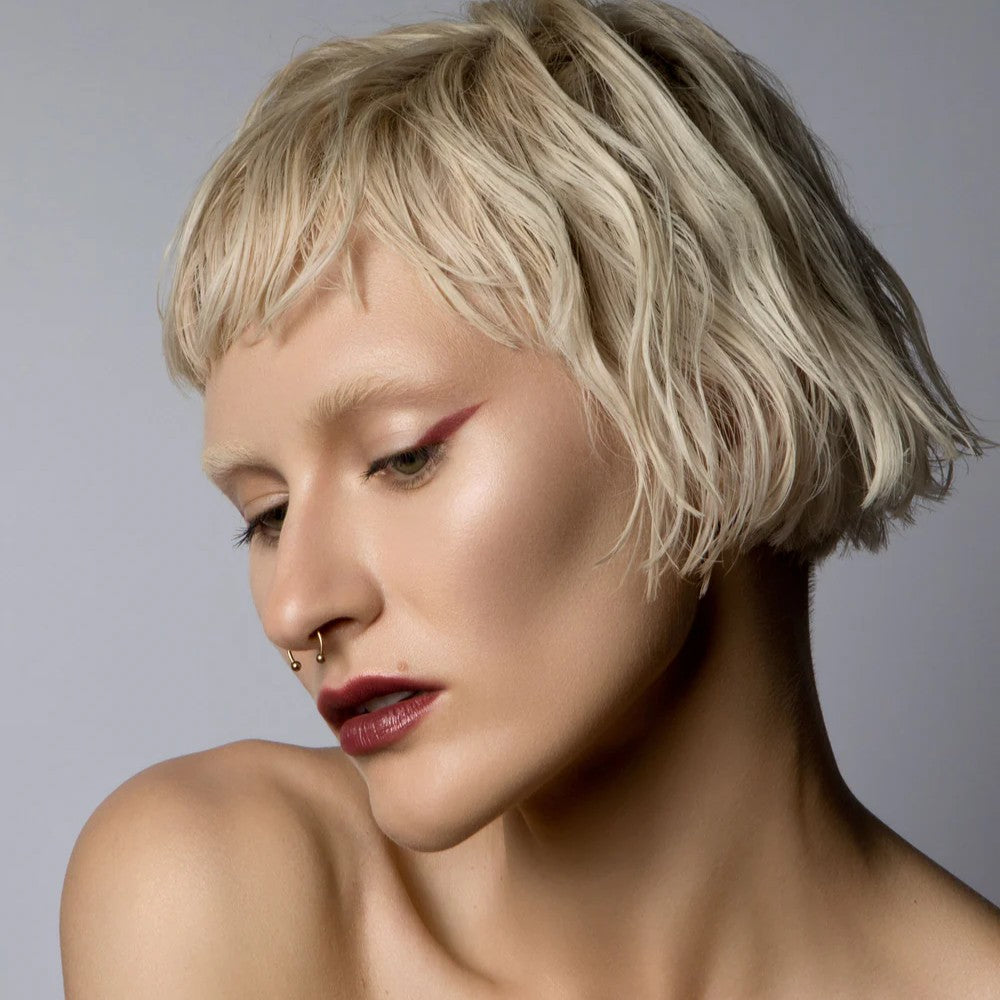 Woman with short blonde hair against a gray background. RITUEL DE FILLE Inner Glow Crème Pigment Intuition