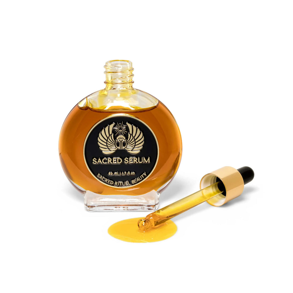Glass bottle of Sacred Rituel Sacred Serum face oil, featuring a golden botanical blend made with organic plant oils and extracts for a radiant appearance. 50 ml dropper