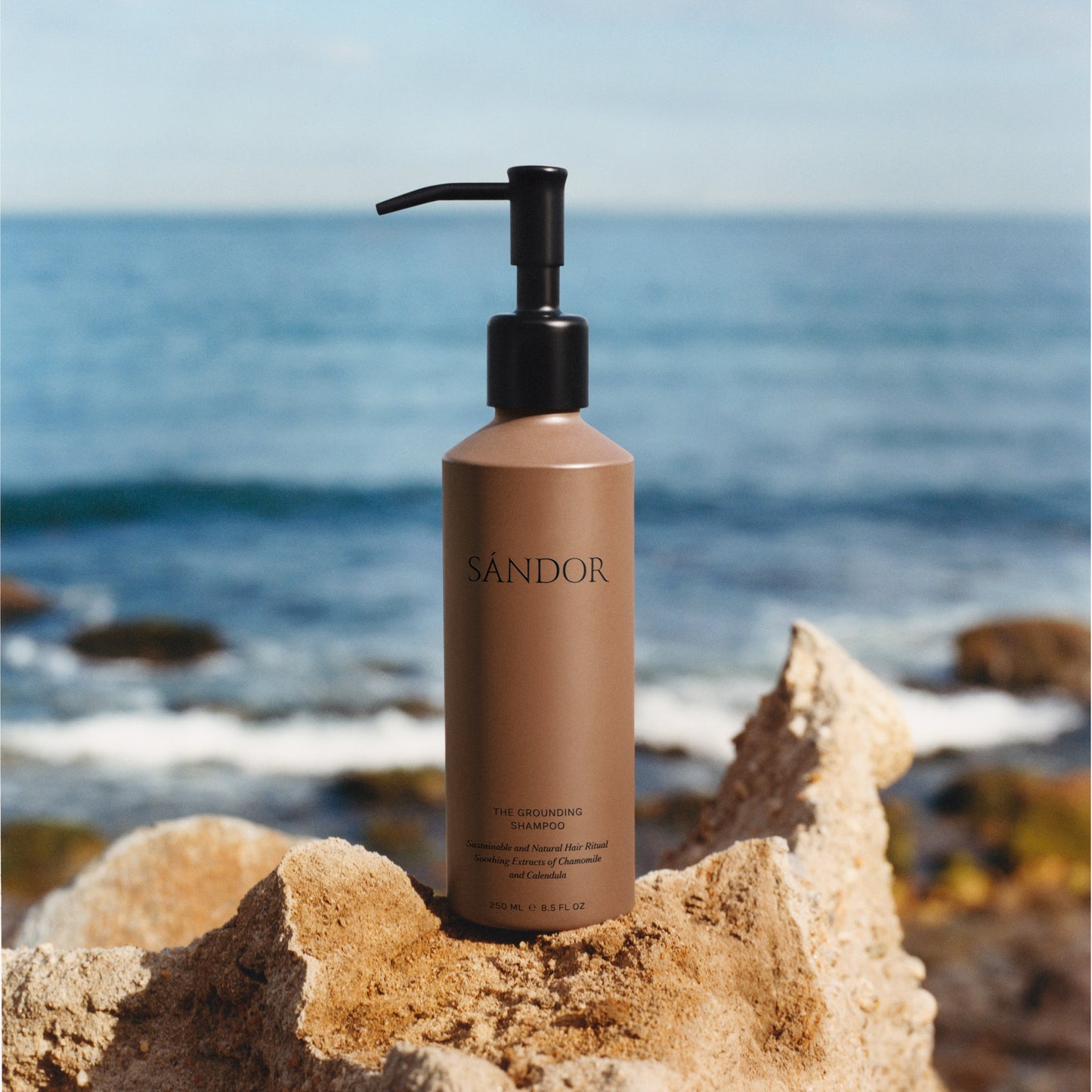 SÁNDOR The Grounding Shampoo shampoo bottle with pump on a rock by the ocean