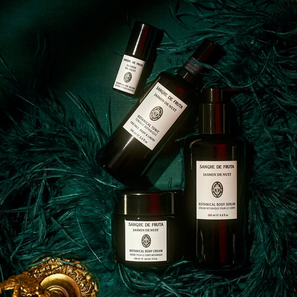 Cosmetic bottles and jars with labels on a textured green surface