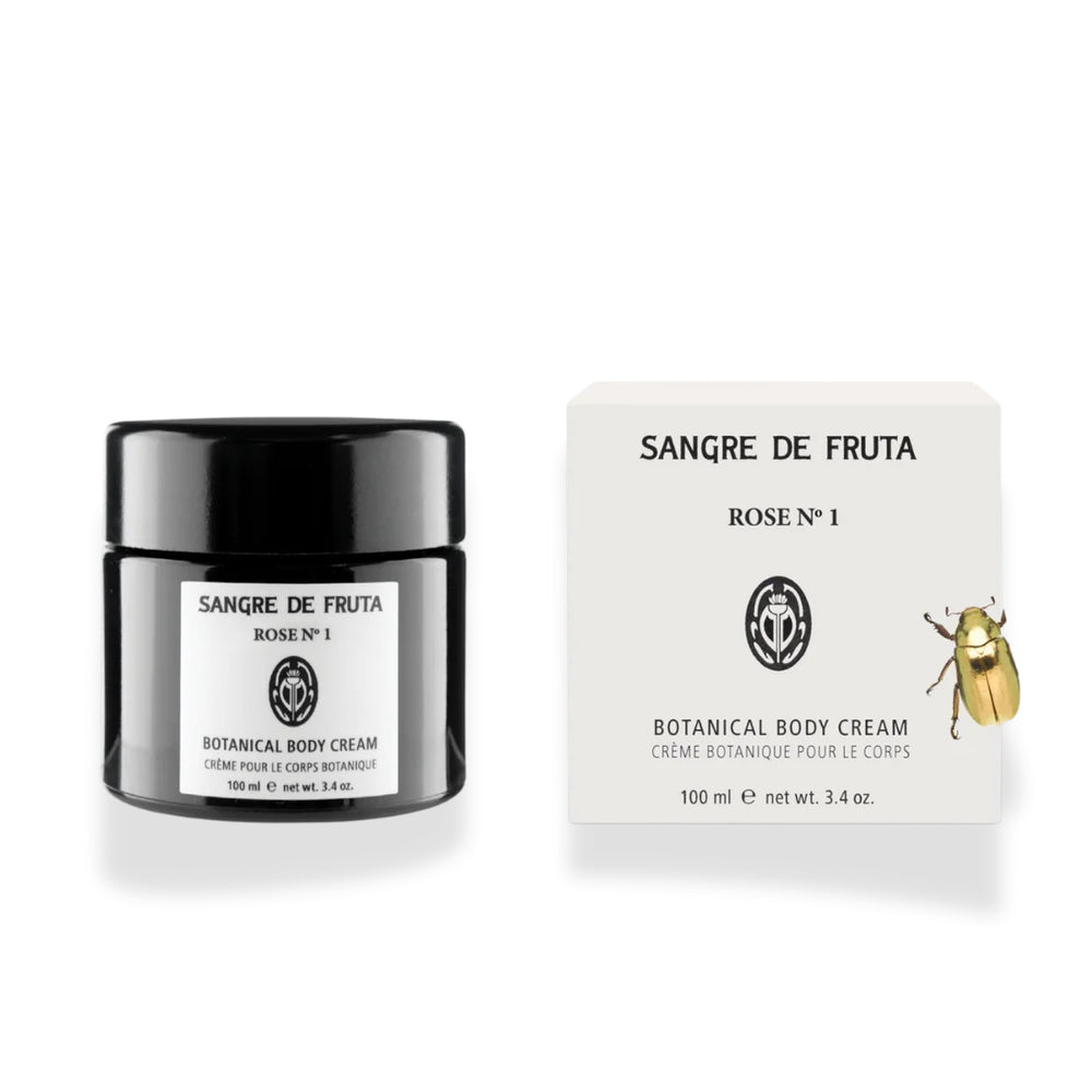 Sangre de Fruta Botanical Body Cream with a rich whipped texture, shown in black glass jar next to its packaging, on white background.