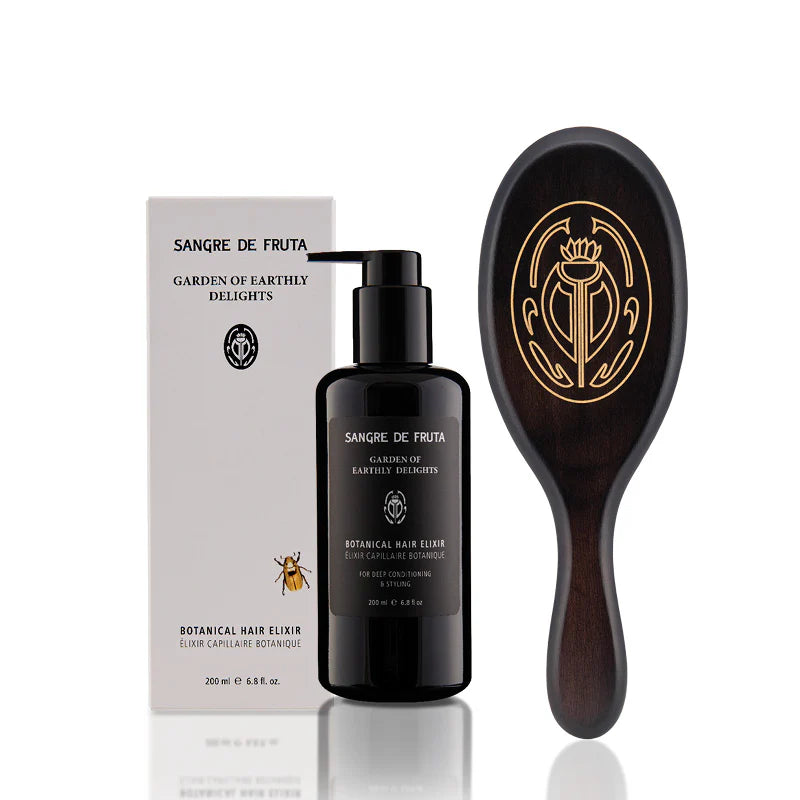 SANGRE DE FRUTA Brush it Off Set, including Botanical Hair Elixir in a violet glass bottle and hand-carved beech wood hair brush with mixed nylon bristles for scalp nourishment.