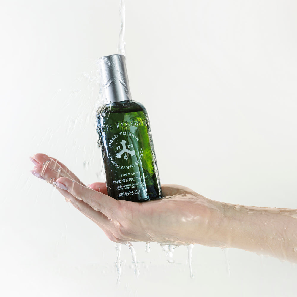 Seed to Skin Tuscany The Seru'mist hydro-active body serum in a dark green bottle with a white cap, on a white background.