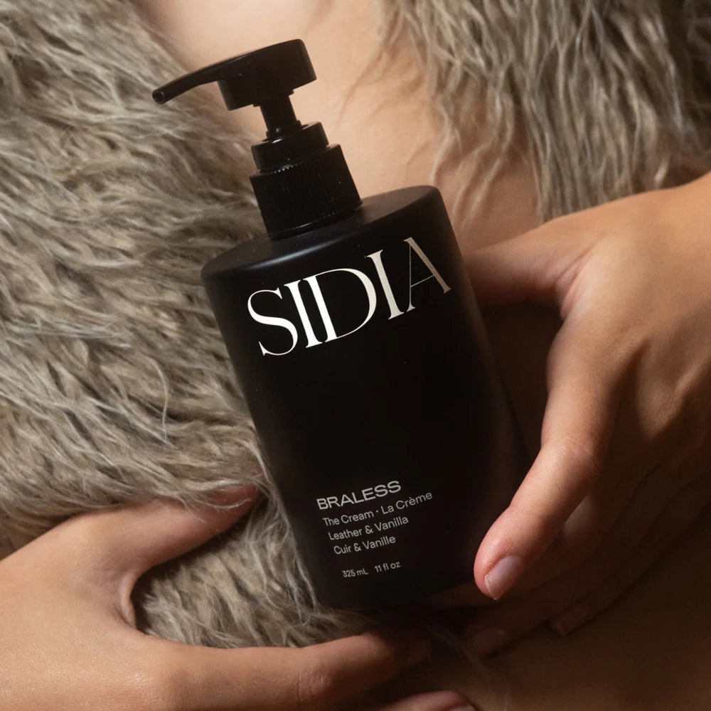 SIDIA BRALESS Cream hand and body moisturizer in a bottle with a black pump, a rich yet quick-drying cream with coconut, soft woods, and leather-inspired fragrance notes.