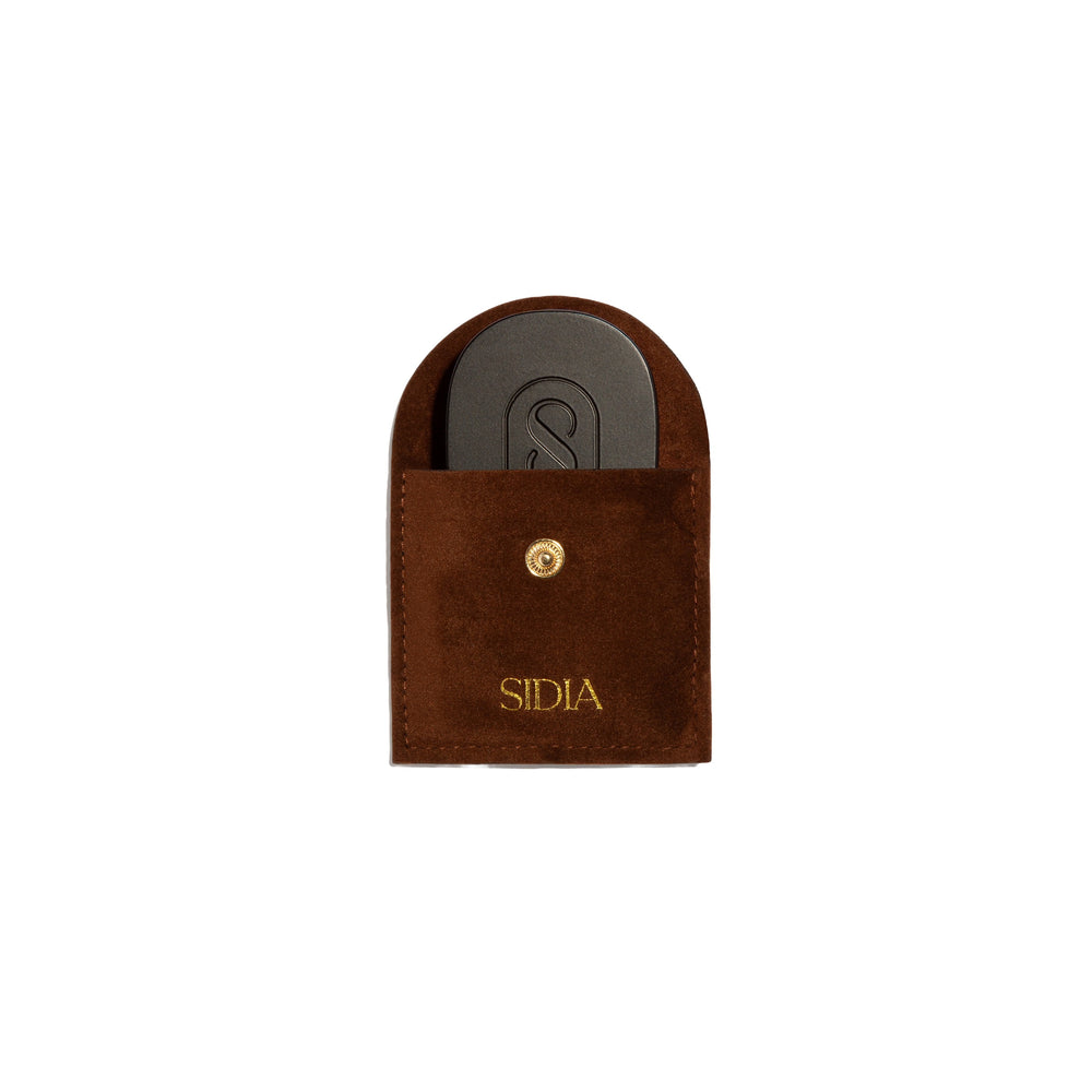 Brown pouch with a black solid perfume inside, featuring the brand 'Sidia' on the pouch, on a white background.