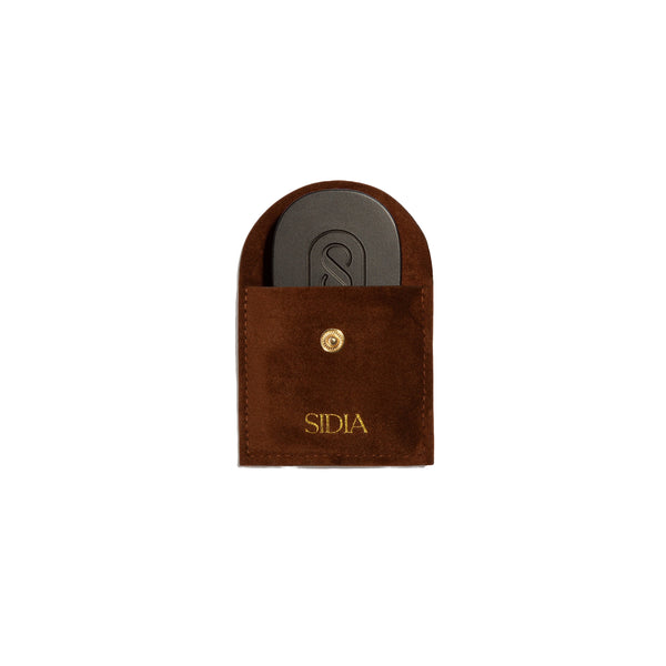 Brown pouch with a black solid perfume inside, featuring the brand 'Sidia' on the pouch, on a white background.