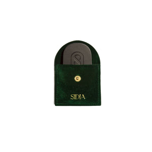 Dark green pouch with a black solid perfume inside, featuring the brand 'Sidia' on the pouch, on a white background.