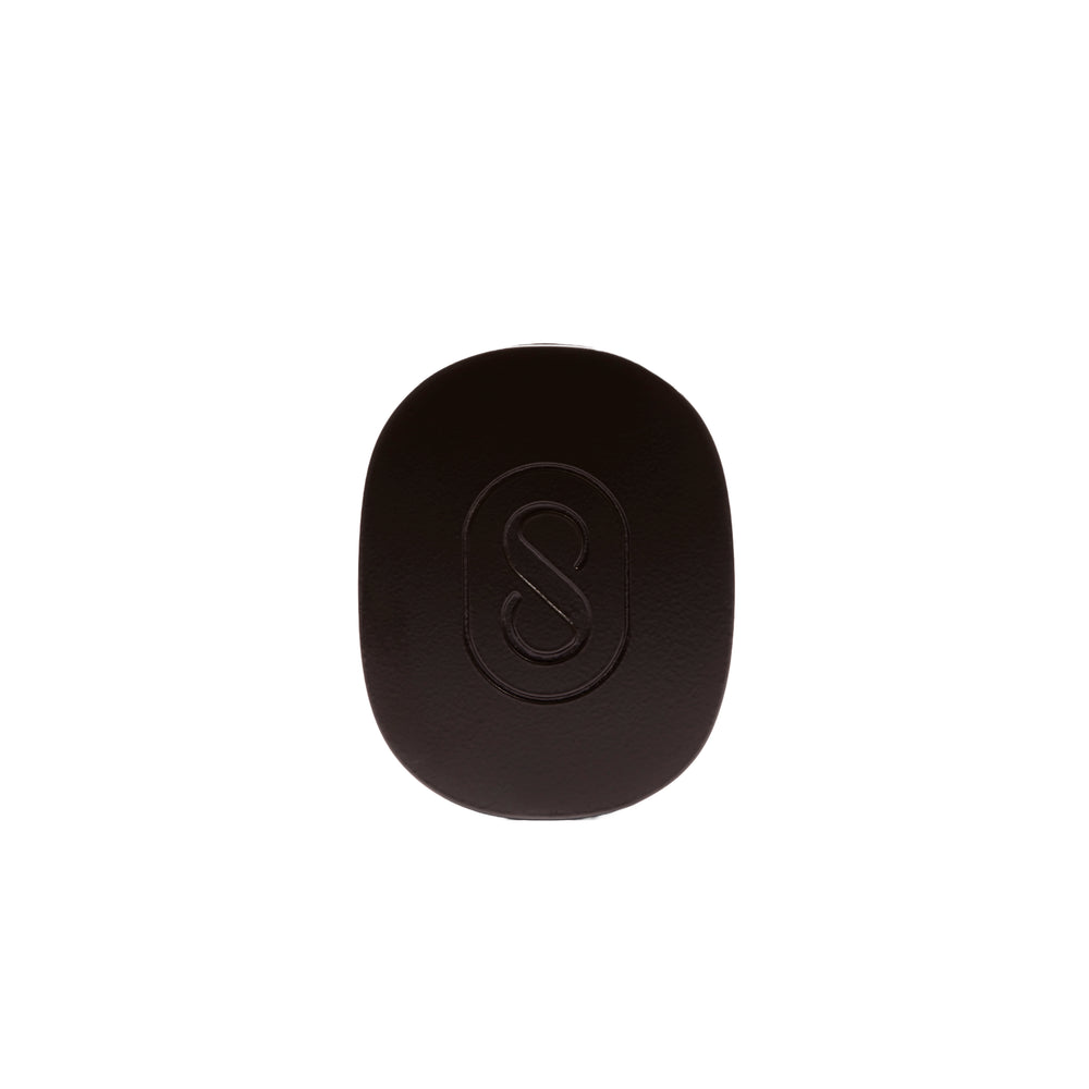 Dark green pouch with a black solid perfume inside, featuring the brand 'Sidia' on the pouch, on a white background.