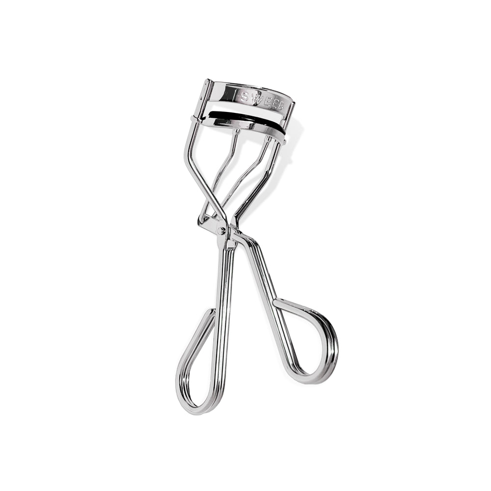 SWEED Eyelash Curler with a sleek design, crafted from high-quality material for a long-lasting, effortless lash lift. Includes a replacement pad for extended use. Vegan and cruelty-free.