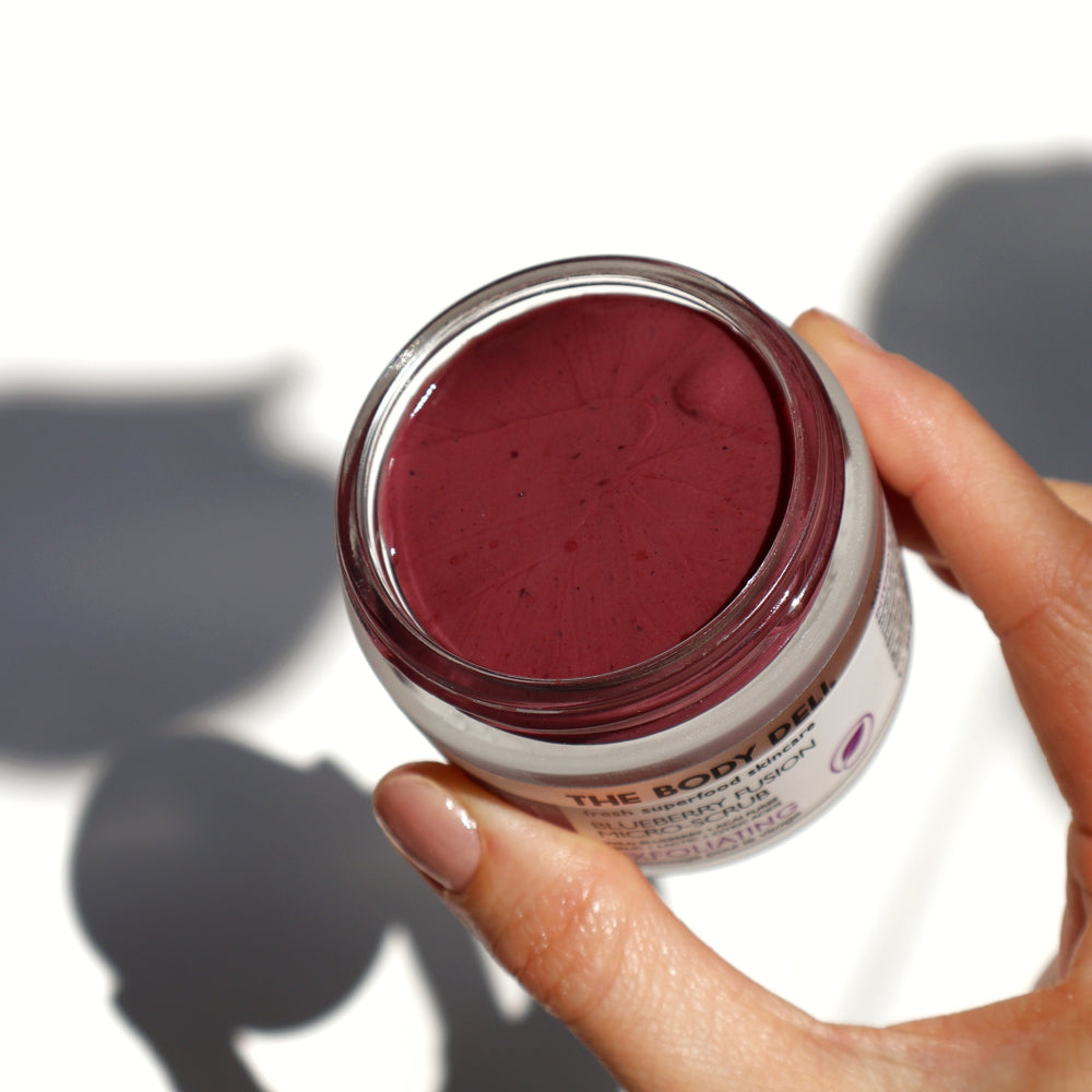 THE BODY DELI BLUEBERRY FUSION Scrub – antioxidant-rich exfoliating facial scrub with blueberry and acai, featuring natural fruit acids and fine earth particles in a 2oz jar.