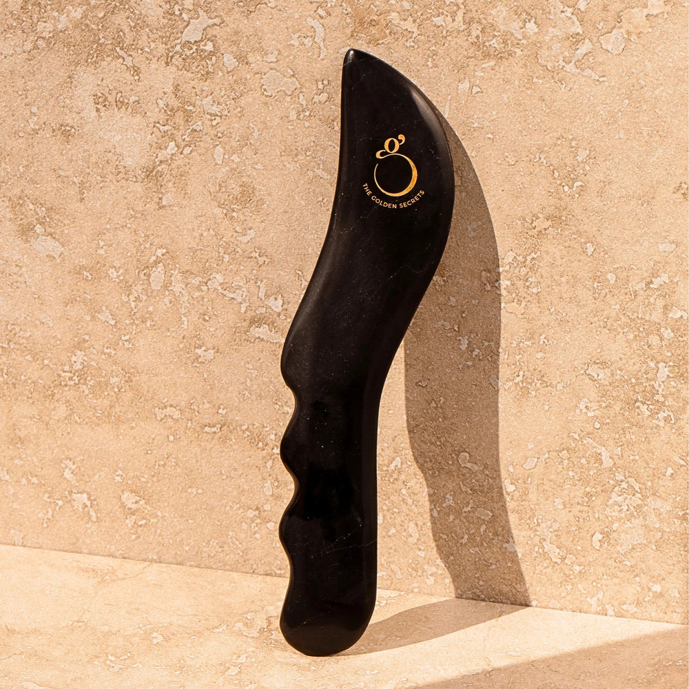 The Golden Secrets Sculpting Stone Gua Sha Body Tool made from Sibin Bian stone with unique properties like Far Infra-Red waves and ultrasonic pulses, designed to elevate your beauty ritual.