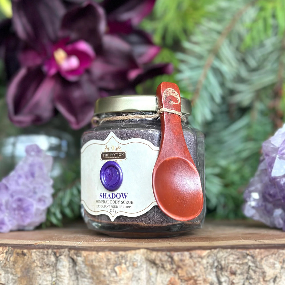 THE POTION COSMETICS Shadow Mineral Body Scrub jar with Dead Sea Salt, pumpkin seeds, and spices, evoking a deep forest and winter spice aroma.