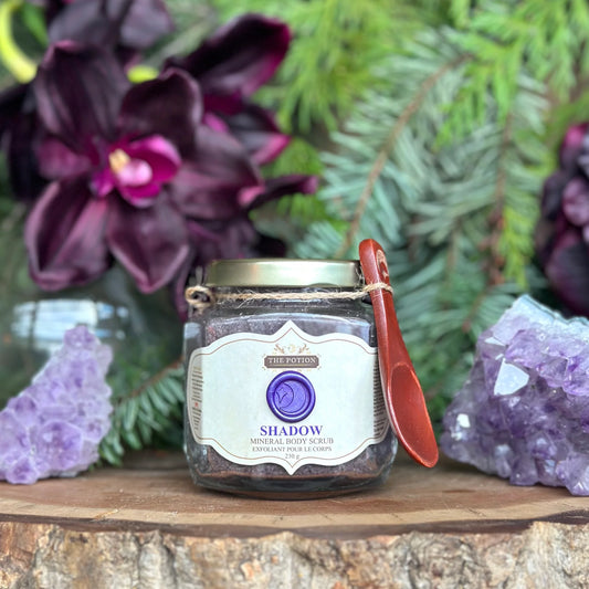 THE POTION COSMETICS Shadow Mineral Body Scrub jar with Dead Sea Salt, pumpkin seeds, and spices, evoking a deep forest and winter spice aroma.