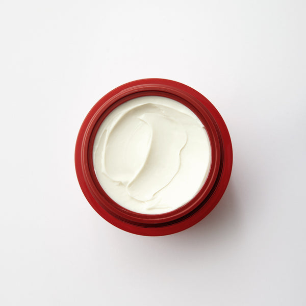 Red jar with white cream on a white background. TRONQUE Firming Butter