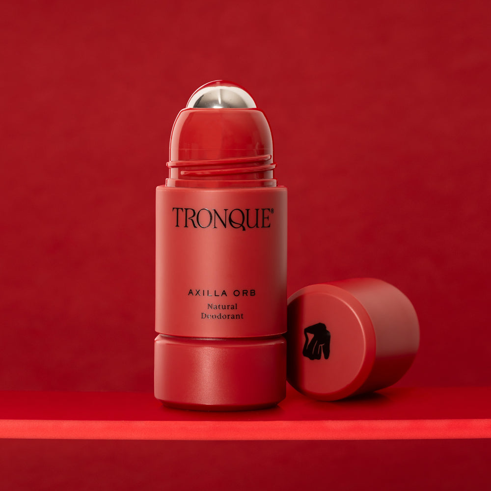 Red deodorant stick with 'Tronque' branding on a white background. TRONQUE Natural Deodorant