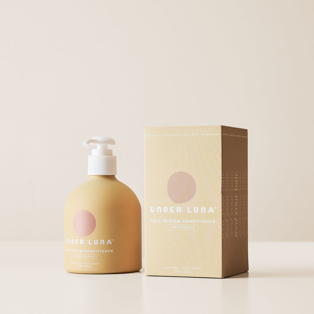 Under Luna Tulsi Bloom Conditioner in recyclable aluminum bottle, enriched with tulsi, nettle, rosemary, and sweet orange for fine to medium hair.