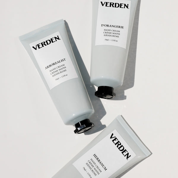 Three tubes of VERDEN hand creams arranged diagonally on a clean white background with soft shadows. The tubes are frosted white with black caps and feature labels for 'ARBOREALIST', 'D'ORANGERIE', and 'HERBANUM'.