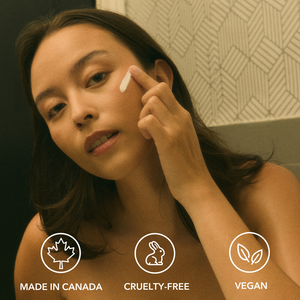 Woman applying cream to her face with product icons and text indicating 'Made in Canada', 'Cruelty-Free', and 'Vegan' below. VINTAGE NOON Vacation Skin Overnight Mask and Moisturizer