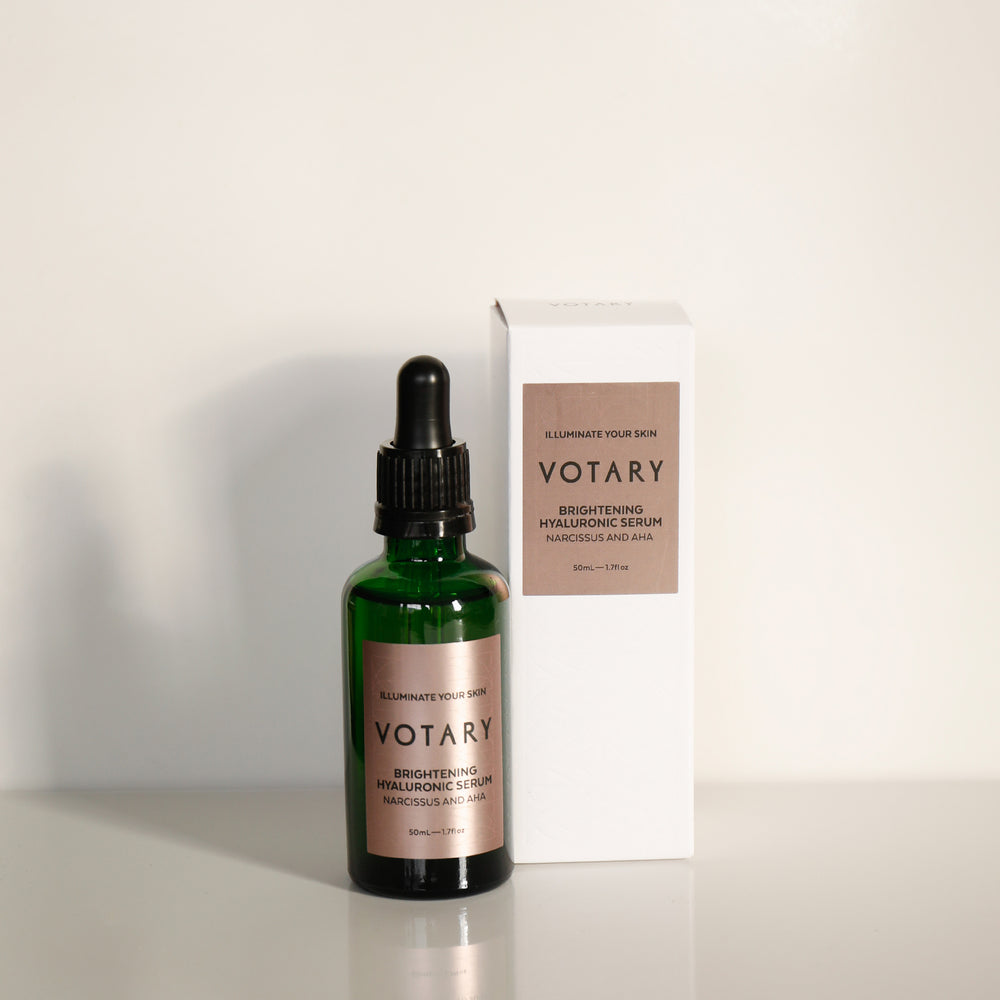 VOTARY Brightening Hyaluronic Serum – A clear, lightweight serum in a green glass bottle with dropper. Contains hyaluronic acid, glycolic acid, and narcissus extract to hydrate and visibly improve skin tone.