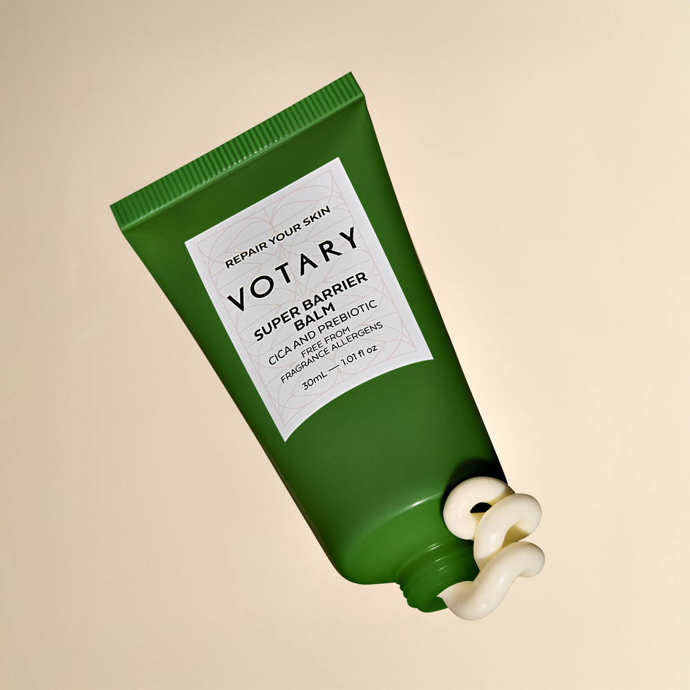 Green tube of Votary Super Barrier Balm on a white background